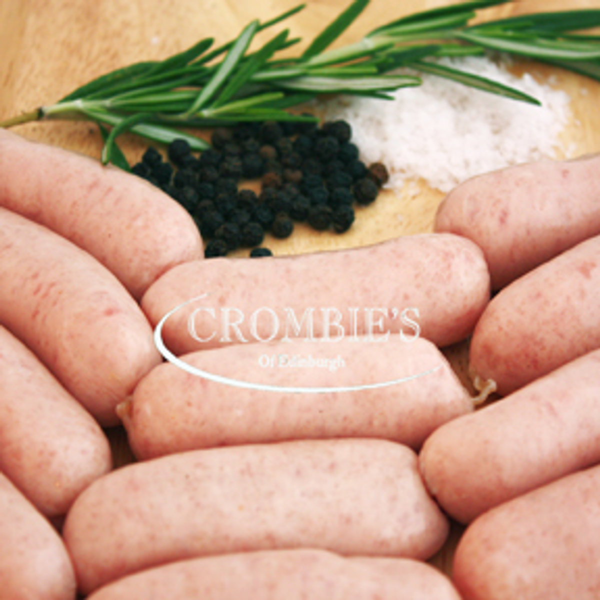 Fresh white pork sausages on a board scattered with black peppercorns