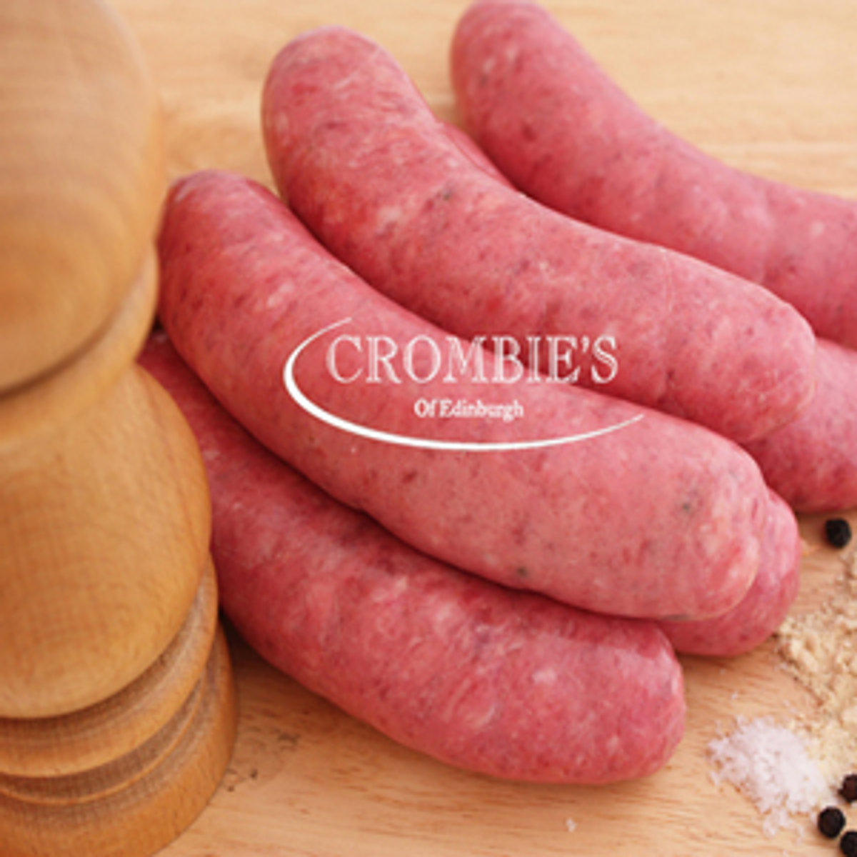 Deep-red beef sausages coiled on a wooden board