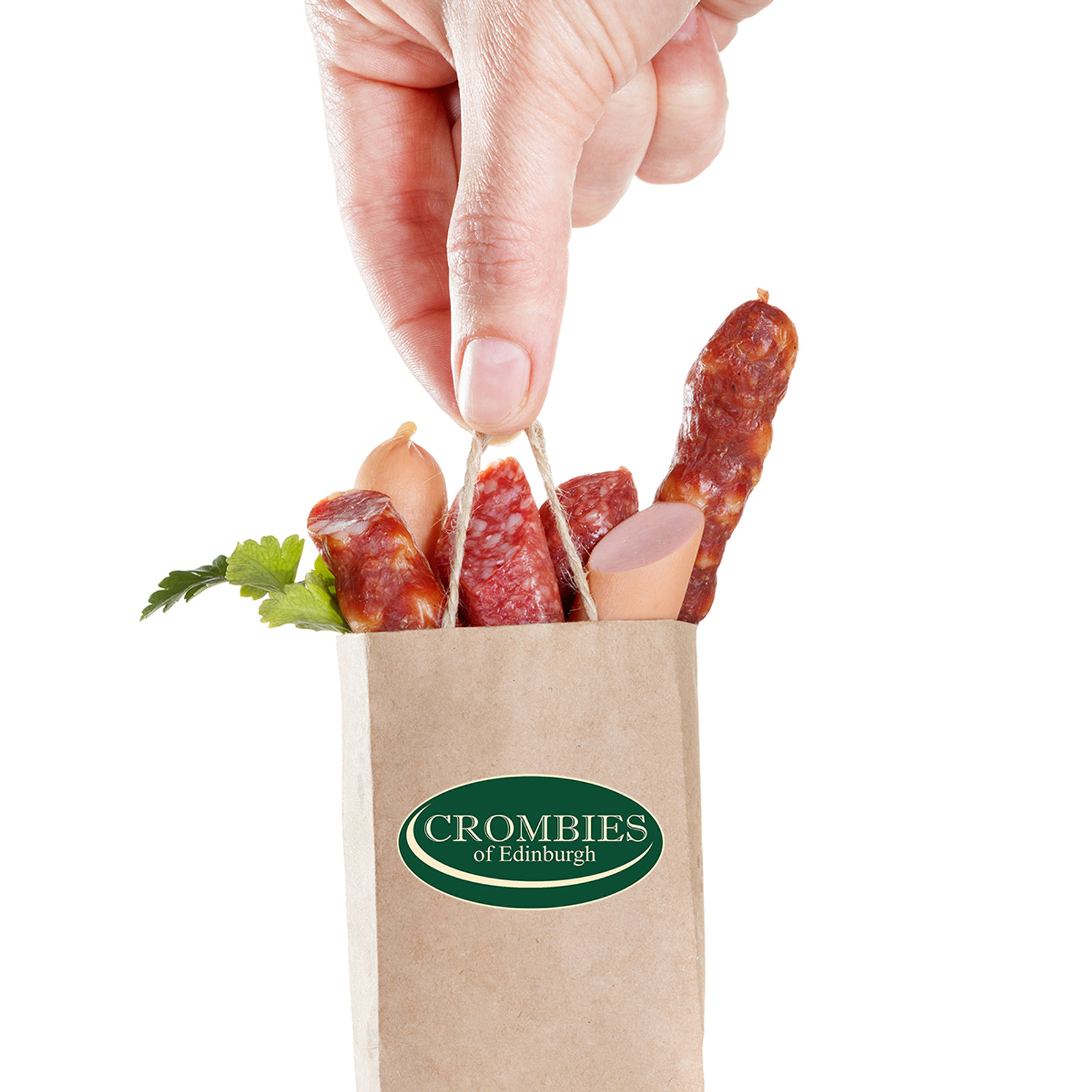 A hand holding a Crombies of Edinburgh paper bag filled with cured meats and salami sticks