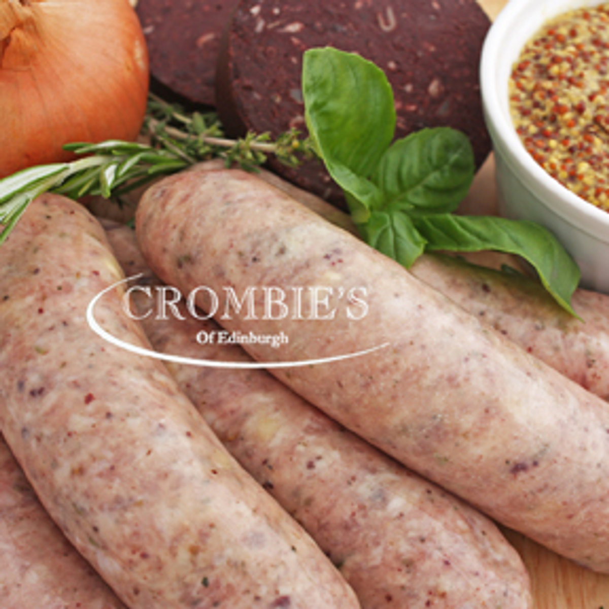 Pork sausages dressed with fresh basil beside a pot of grain mustard