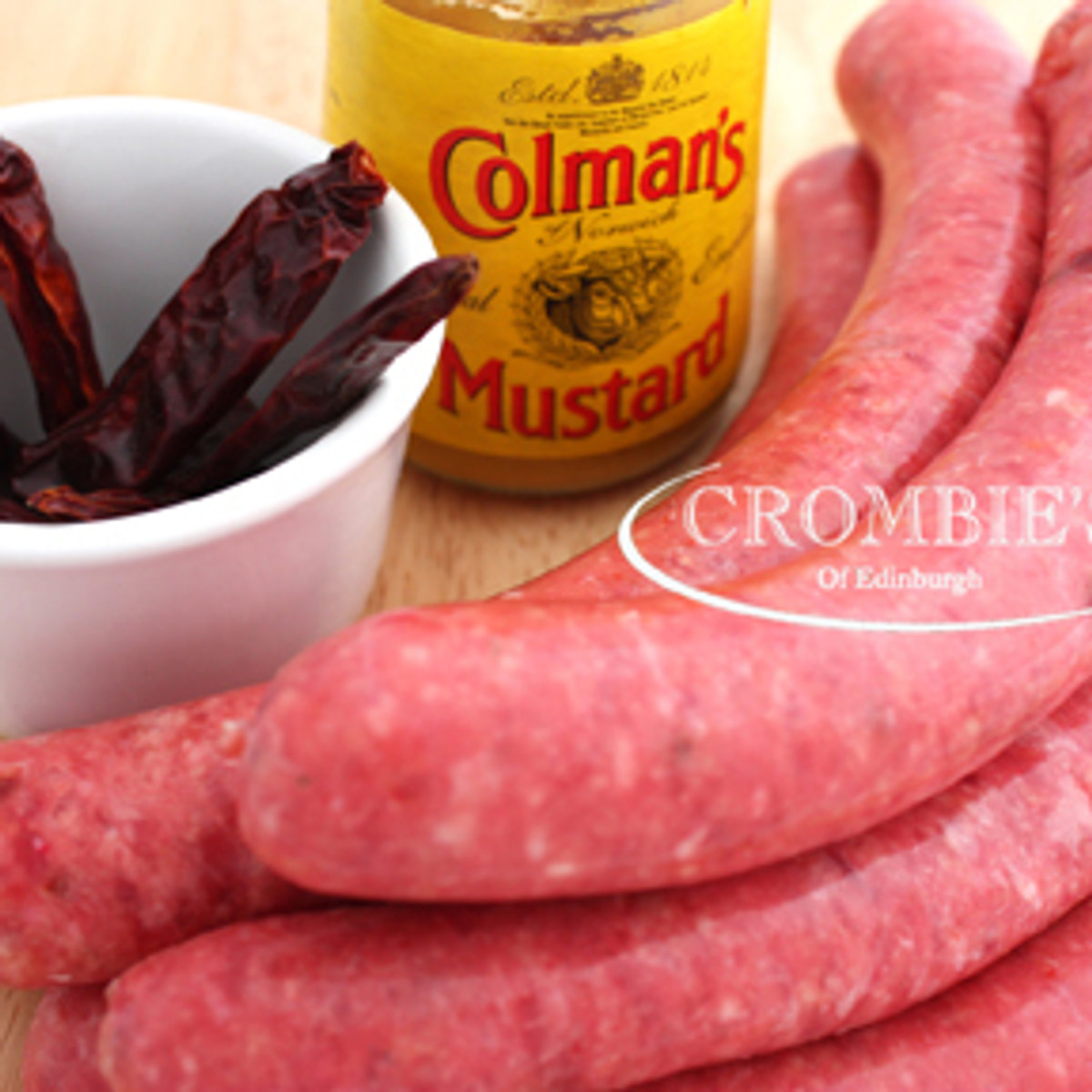 Red beef sausages with a jar of English mustard and dried chillies